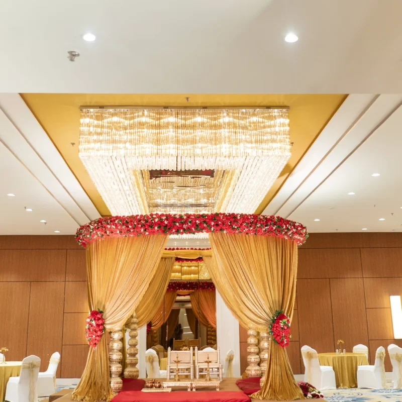 Spacious wedding hall in Thane with golden mandap and floral decor.